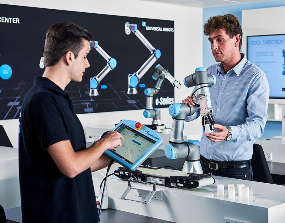 Learners receiving hands-on collaborative robot training in an advanced robotics facility