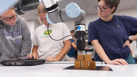 Robotics trainees learning robot programming and operations in a modern laboratory